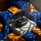 CTRL8 A6S wireless earbuds in sleek black charging case displayed on a concrete block surrounded by geometric shapes and shadows.