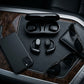 CTRL8 X29 open-ear headphones with charging case placed on a car console alongside sunglasses and a smartphone for on-the-go audio
